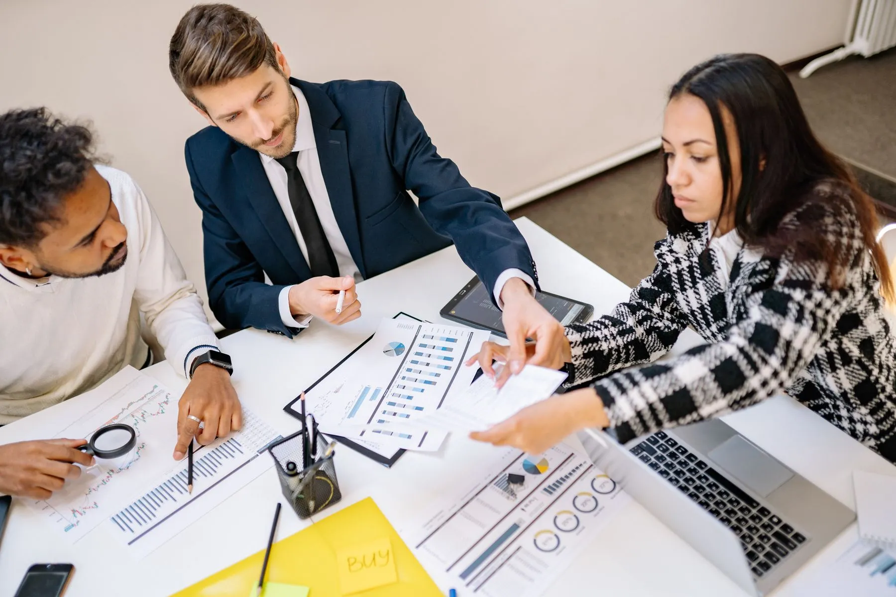 A team reviewing cost reports and figures around a desk