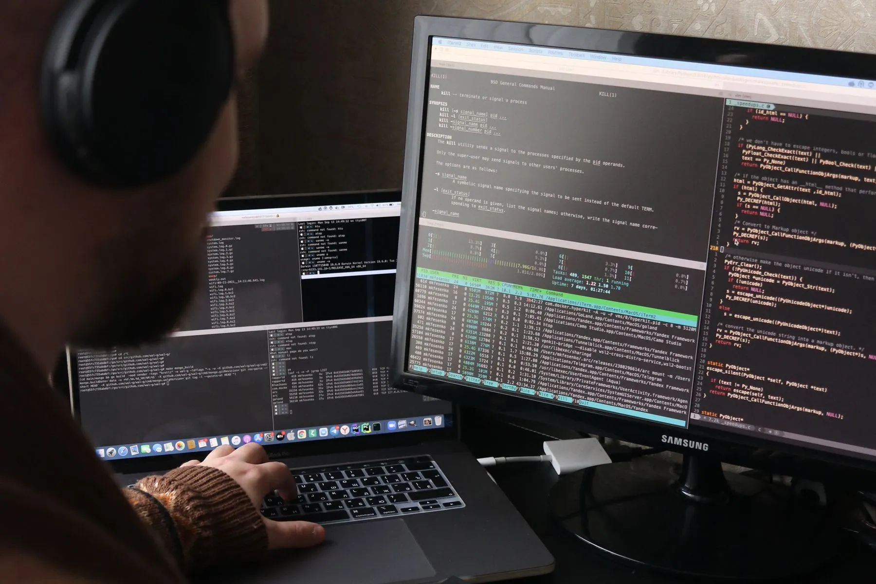 An engineer watching build pipelines across dual monitors